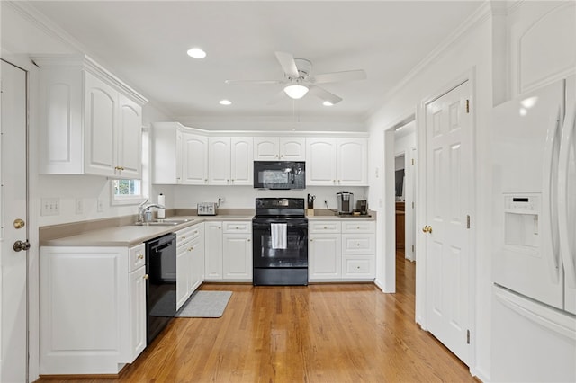 kitchen featuring ornamental molding, black appliances, white cabinets, and light hardwood / wood-style floors