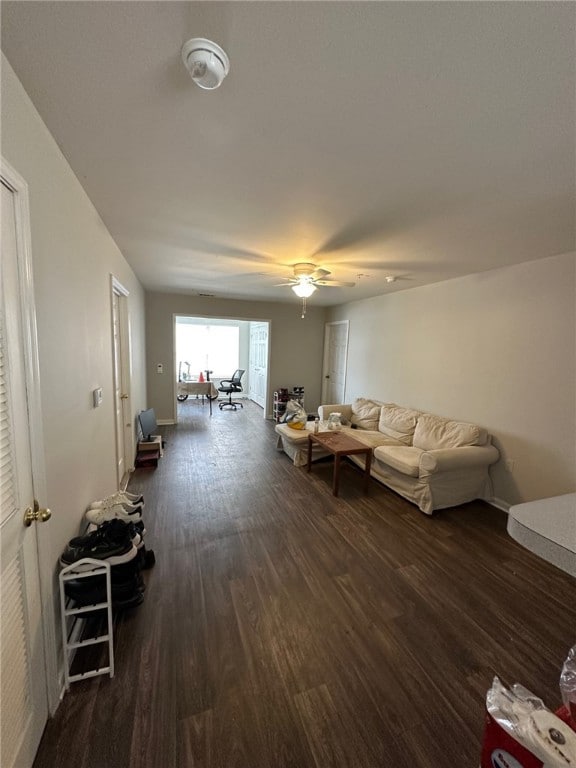 unfurnished living room featuring ceiling fan and dark hardwood / wood-style flooring