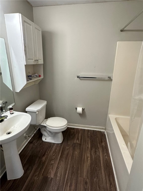 bathroom with toilet, shower / tub combo with curtain, and hardwood / wood-style floors