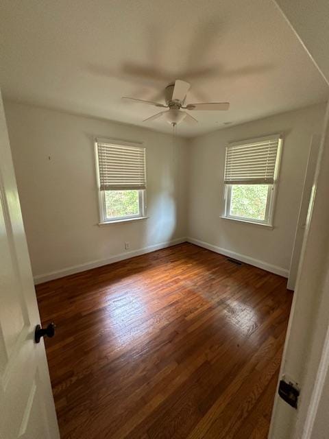 empty room featuring dark hardwood / wood-style flooring, plenty of natural light, and ceiling fan