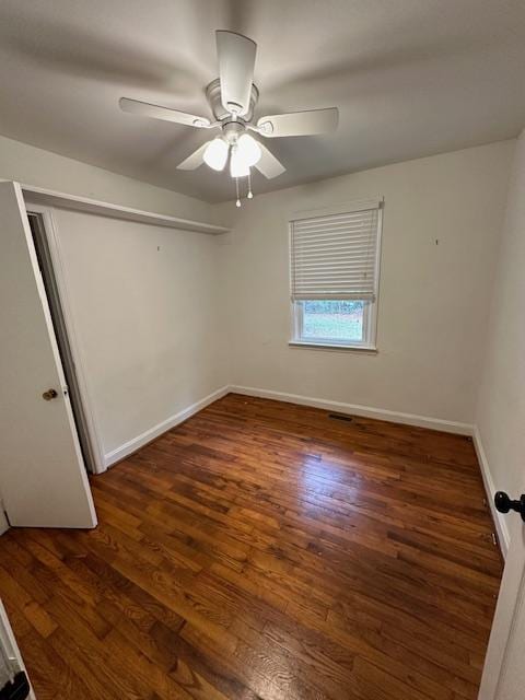 unfurnished room with ceiling fan and dark hardwood / wood-style flooring