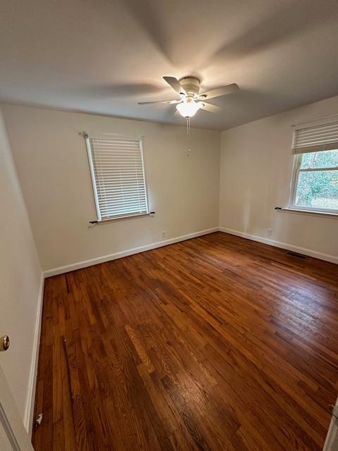 unfurnished room with ceiling fan and dark hardwood / wood-style floors