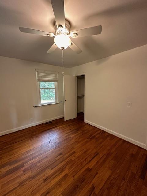 unfurnished bedroom with dark wood-type flooring, ceiling fan, and a closet