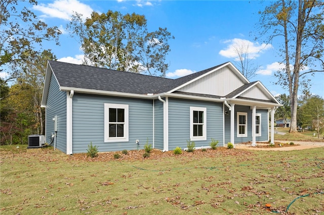 single story home featuring roof with shingles, central AC unit, and a front lawn