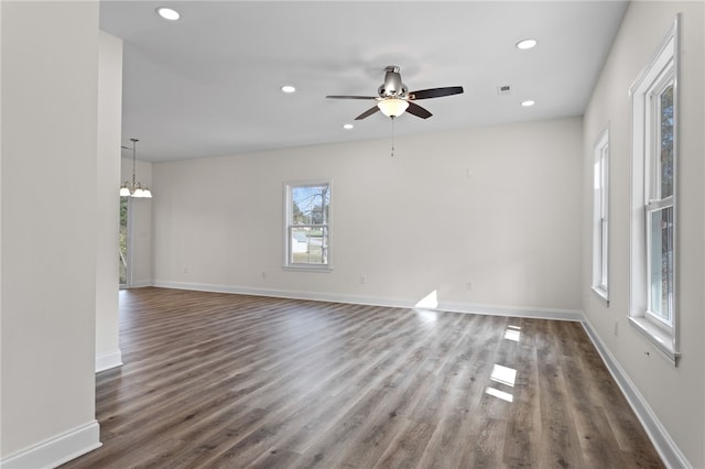 empty room with baseboards, dark wood-type flooring, and recessed lighting