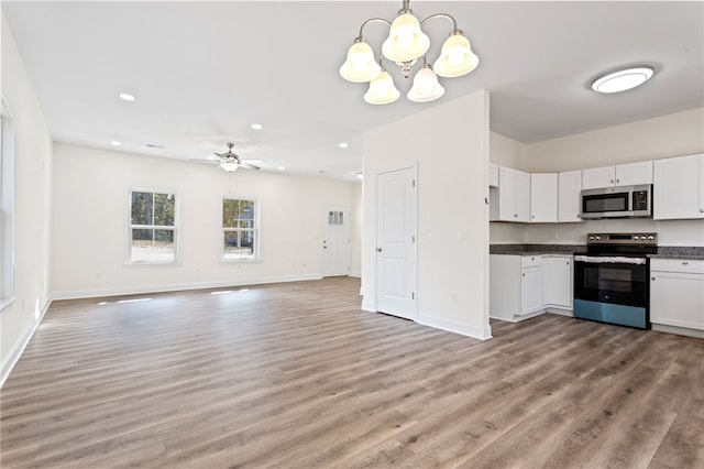 kitchen with stainless steel appliances, dark countertops, light wood-type flooring, and white cabinetry