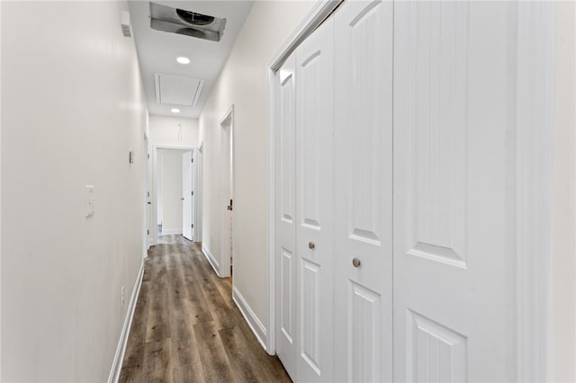 hall featuring attic access, visible vents, baseboards, and dark wood-style flooring