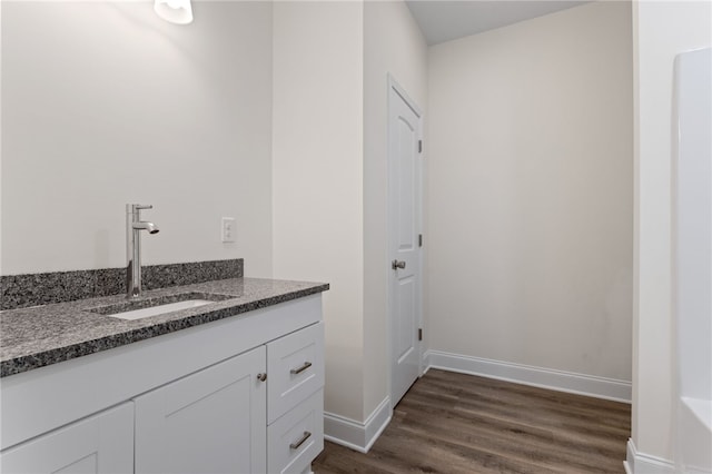 bathroom featuring baseboards, wood finished floors, and vanity