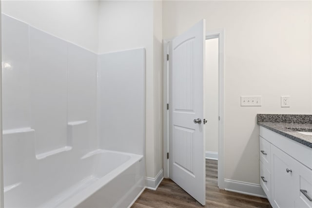 full bathroom with baseboards, wood finished floors, and vanity