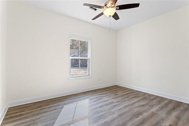 empty room with ceiling fan, visible vents, baseboards, and wood finished floors