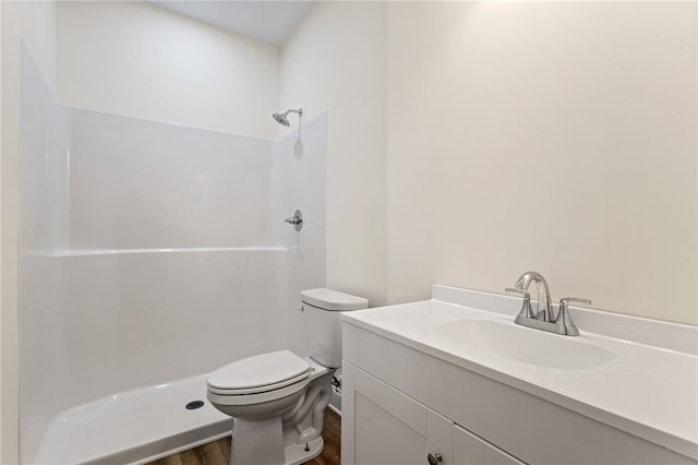 full bathroom with toilet, a shower, wood finished floors, and vanity