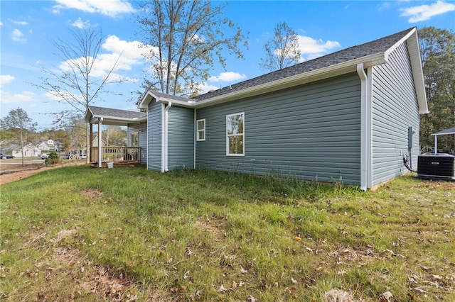 view of side of property featuring a lawn and central air condition unit