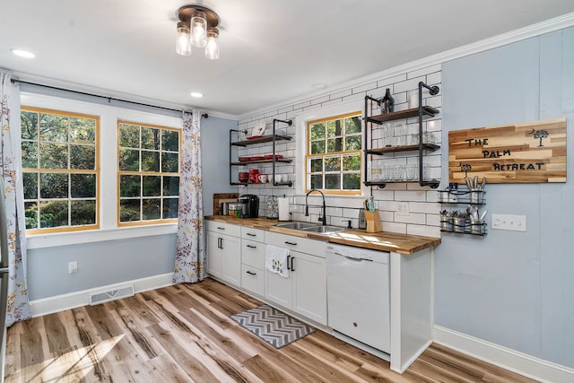 kitchen featuring white cabinetry, wood counters, white dishwasher, light hardwood / wood-style floors, and sink