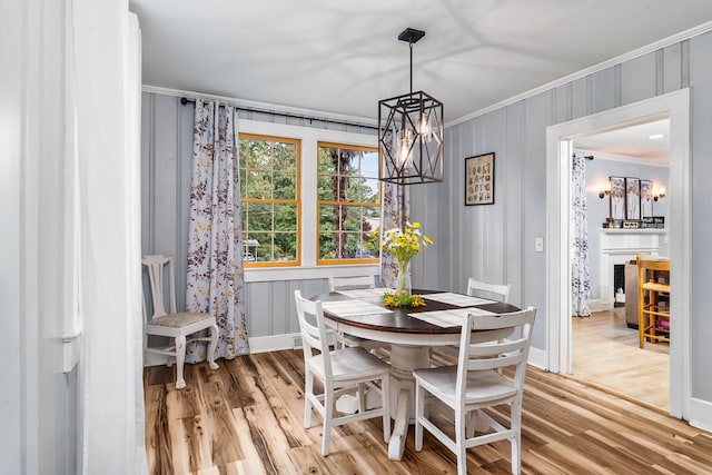 dining area featuring light hardwood / wood-style floors, ornamental molding, and an inviting chandelier