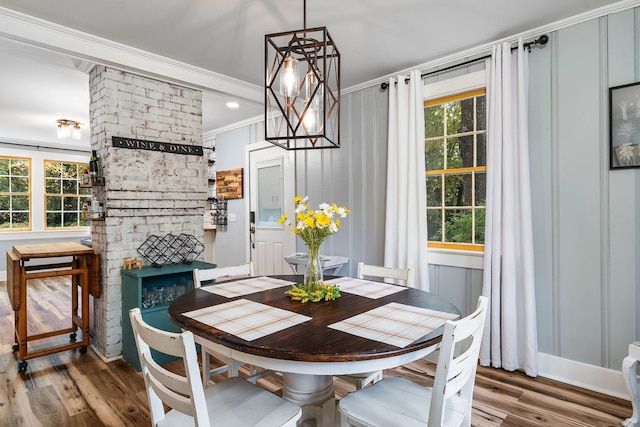 dining area with hardwood / wood-style floors, crown molding, and a healthy amount of sunlight