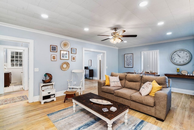 living room featuring ornamental molding, light hardwood / wood-style flooring, and ceiling fan