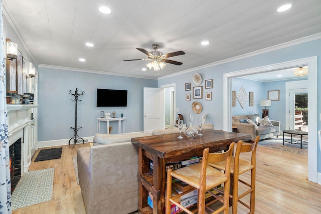 dining space featuring light hardwood / wood-style floors, crown molding, and ceiling fan