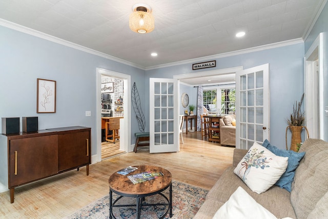 living room with french doors, crown molding, and light hardwood / wood-style flooring