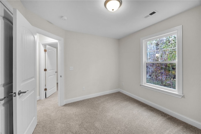 spare room featuring light carpet