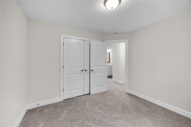 unfurnished bedroom with a closet and light colored carpet