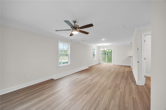 spare room with crown molding, ceiling fan with notable chandelier, light wood-type flooring, and a healthy amount of sunlight