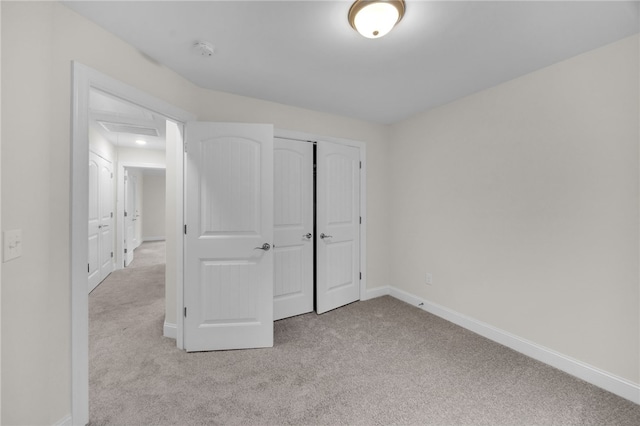 unfurnished bedroom featuring a closet and light carpet