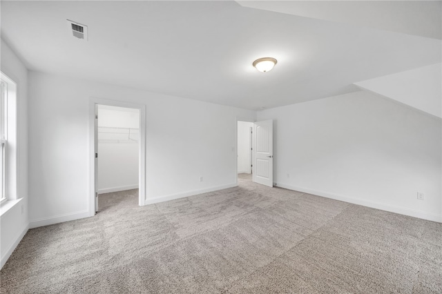 bonus room featuring light carpet and vaulted ceiling