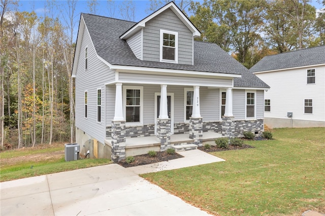 view of front facade featuring a porch, a front lawn, and central AC