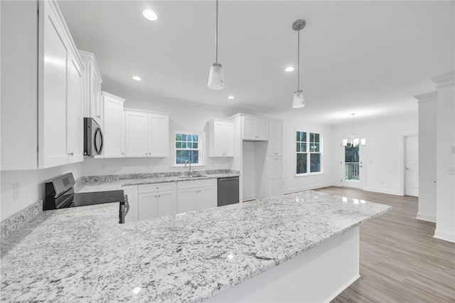 kitchen featuring stainless steel appliances, decorative light fixtures, and white cabinets