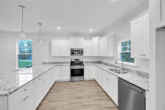 kitchen with stainless steel appliances, sink, decorative light fixtures, plenty of natural light, and white cabinets