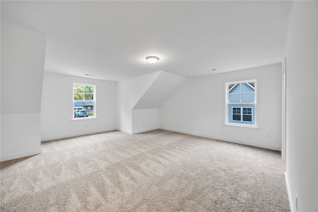 additional living space with vaulted ceiling and light colored carpet