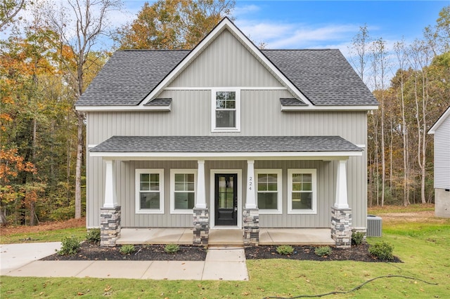 craftsman house with a front yard, a porch, and central AC unit