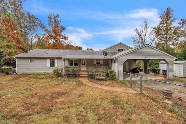 ranch-style home featuring a front yard, a carport, and covered porch