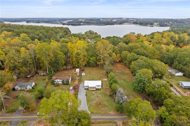 drone / aerial view with a wooded view and a water view