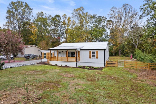 manufactured / mobile home with a front yard, fence, a porch, crawl space, and metal roof