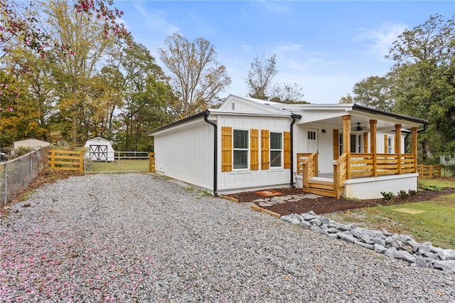 view of front of home with a ceiling fan, fence, driveway, covered porch, and board and batten siding