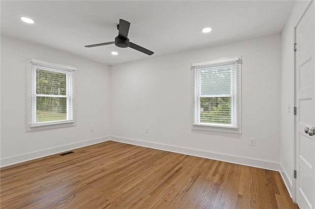 spare room with recessed lighting, light wood-type flooring, baseboards, and a healthy amount of sunlight