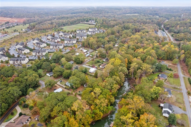 drone / aerial view featuring a residential view and a view of trees