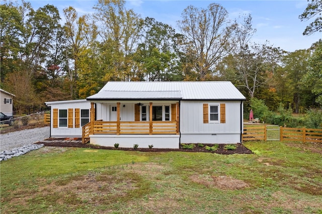 view of front of property with crawl space, covered porch, a front yard, and metal roof