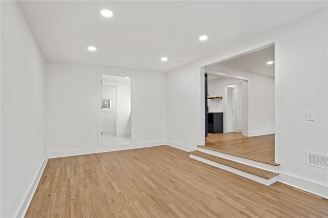 spare room with recessed lighting, light wood-type flooring, baseboards, and visible vents