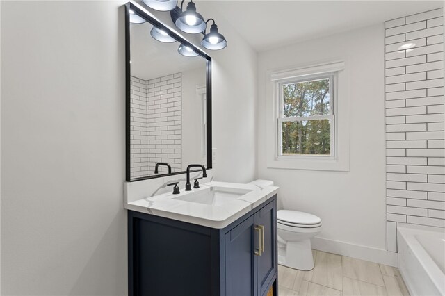 full bath with toilet, vanity, and baseboards