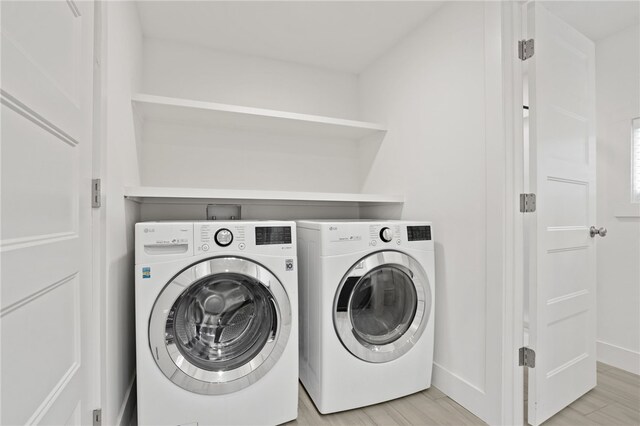 laundry room featuring laundry area, independent washer and dryer, baseboards, and light wood-style floors