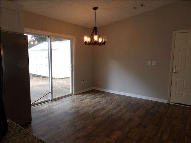 unfurnished dining area featuring dark wood-type flooring and a textured ceiling