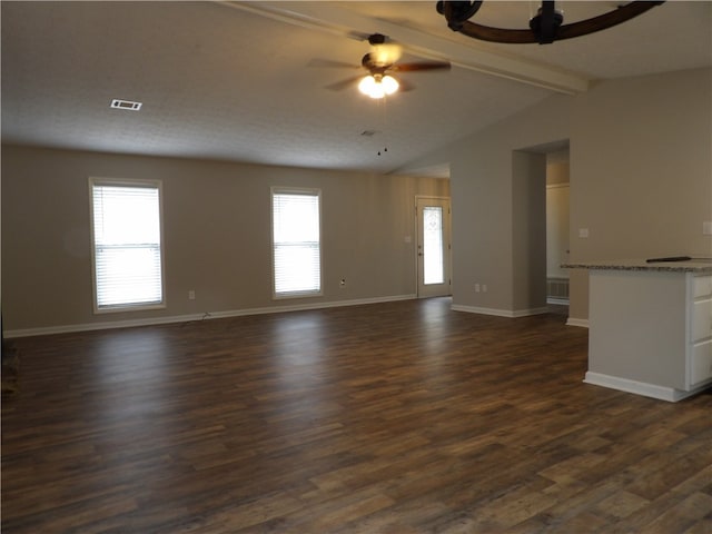 unfurnished living room featuring dark hardwood / wood-style flooring, vaulted ceiling with beams, and plenty of natural light