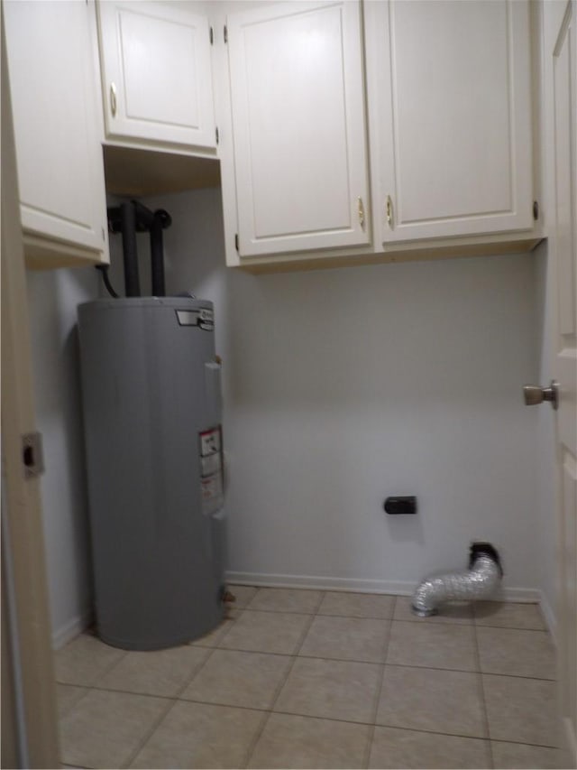 laundry room featuring water heater, baseboards, light tile patterned floors, and cabinet space