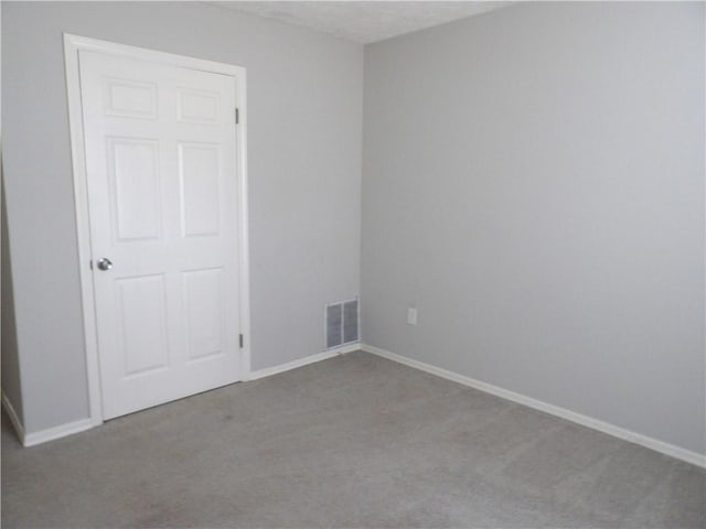 unfurnished room featuring carpet and baseboards
