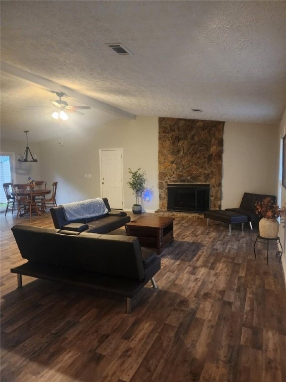 living area with a textured ceiling, dark wood-style floors, ceiling fan, lofted ceiling, and a fireplace