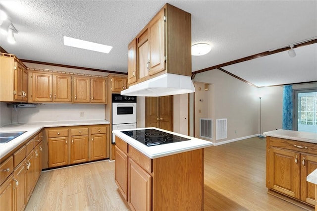 kitchen featuring a center island, light hardwood / wood-style flooring, a textured ceiling, and electric stovetop