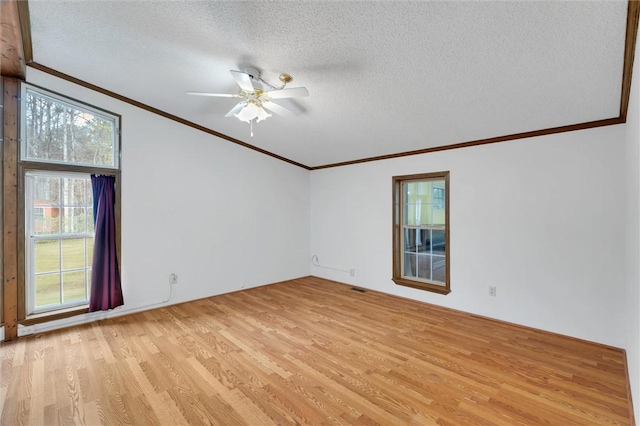 unfurnished room with a textured ceiling, visible vents, a ceiling fan, light wood-type flooring, and crown molding