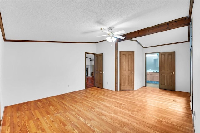 unfurnished bedroom with ceiling fan, vaulted ceiling with beams, ensuite bathroom, light hardwood / wood-style floors, and a textured ceiling